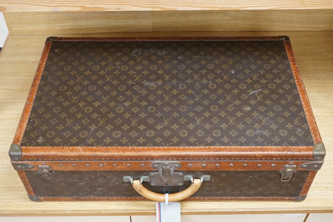 A vintage Louis Vuitton monogram suitcase with two original keys, numbered 793692 to the linen covered interior, height 22cm, width 76cm, depth 46cm